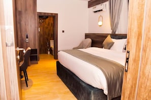Una habitación de hotel con cama, escritorio y zona de ducha.
