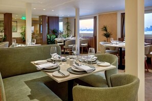 Un restaurante con varias mesas dispuestas para comer, que ofrece vistas del paisaje urbano.