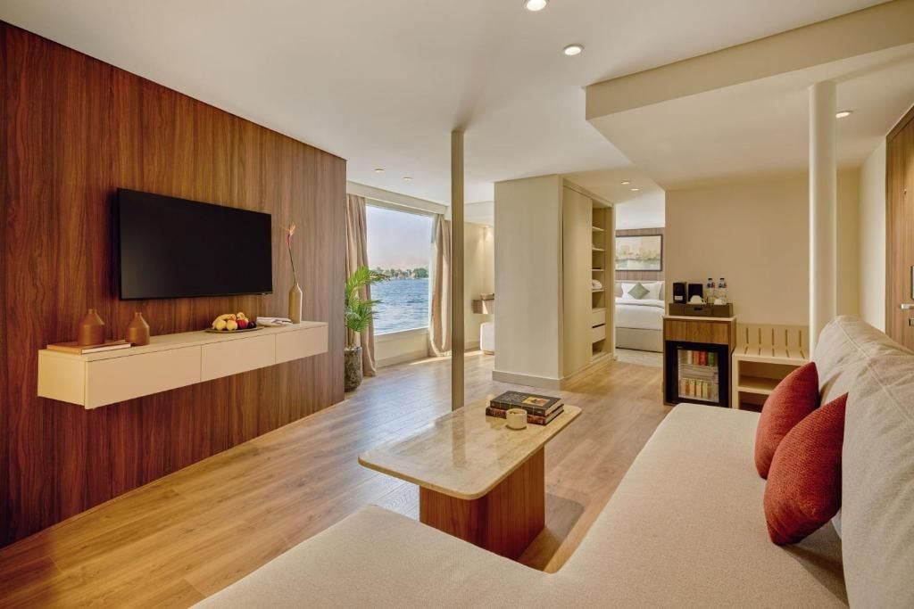 A modern living room with a flat-screen TV, a wooden accent wall, a sofa, and a coffee table.