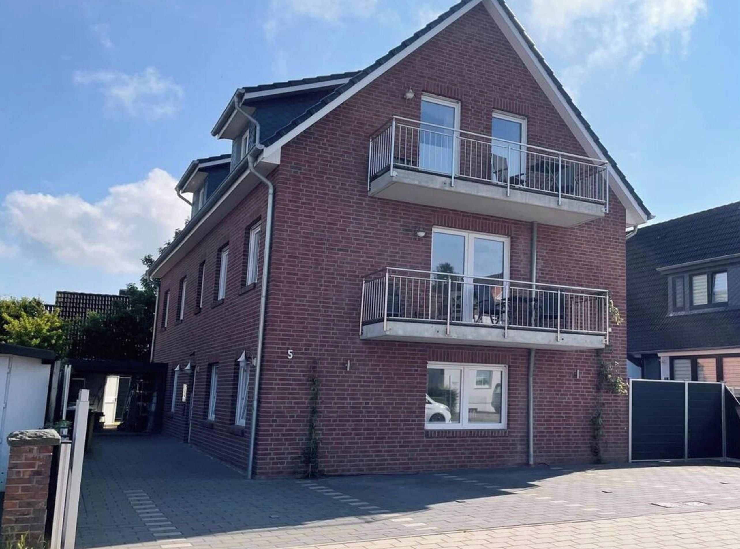 Een tweelaags gebouw van baksteen, met een balkon op de bovenverdieping.