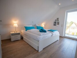 Un dormitorio con cama, mesitas de noche y vistas al exterior.