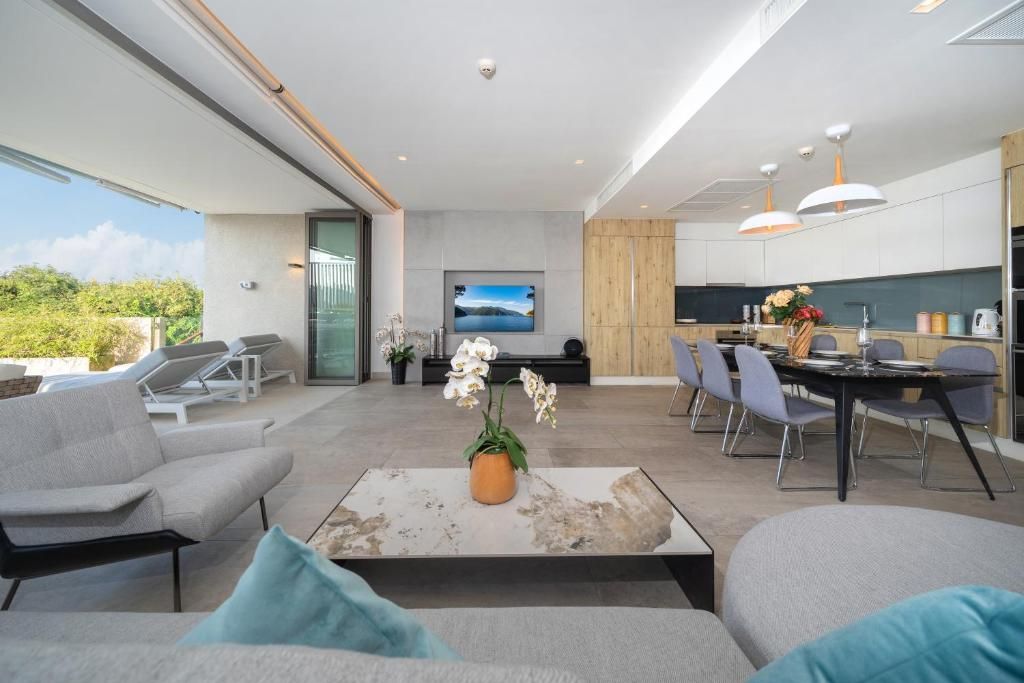 A modern living area with a sofa, a coffee table, and a dining table with chairs.