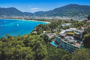 Uma cidade costeira com vista clara para o oceano, edifícios e paisagem acidentada.
