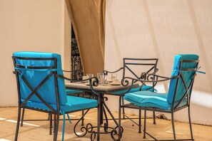 A dining area with a table and four chairs, each with a blue cushion. - Villa With Stunning sea View and Private Pool (Kaş)