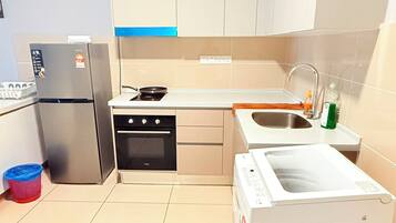 Una cocina moderna con armarios blancos, un refrigerador de acero inoxidable, un horno empotrado, un microondas y un fregadero.