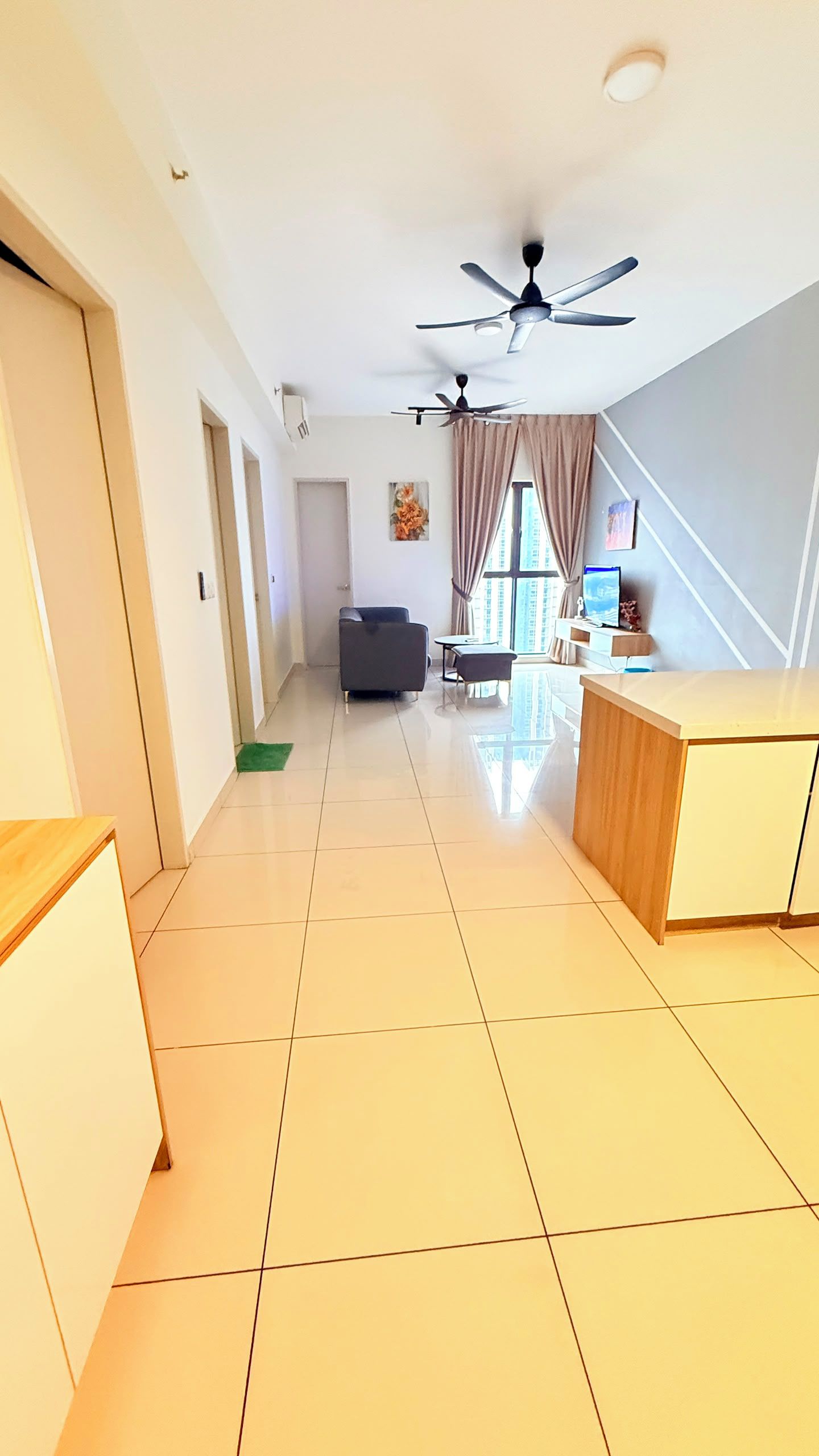 A spacious living area with a ceiling fan, a sofa, a dining table, and a TV.