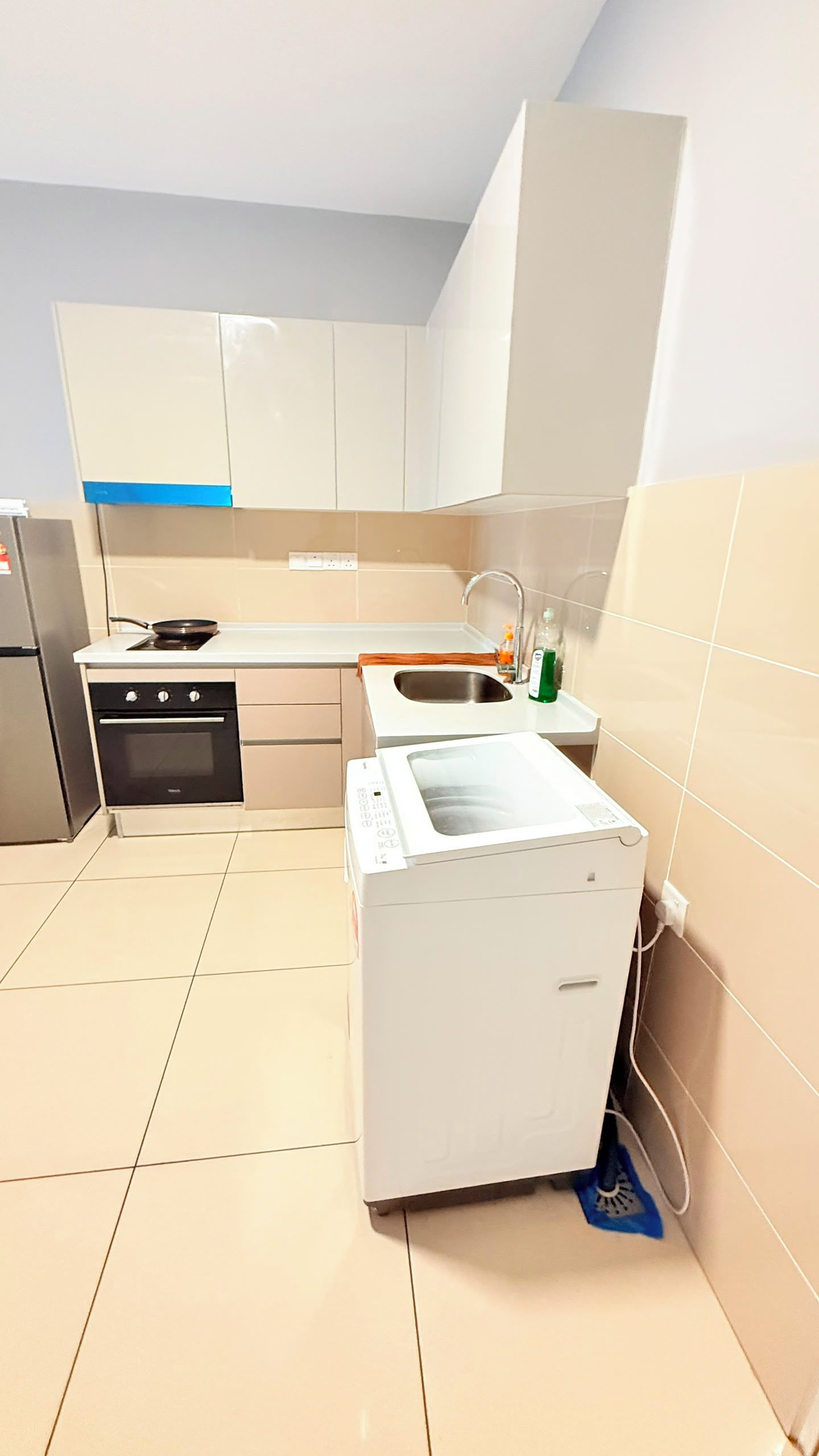 A compact kitchen with a built-in oven, a microwave, and a sink.