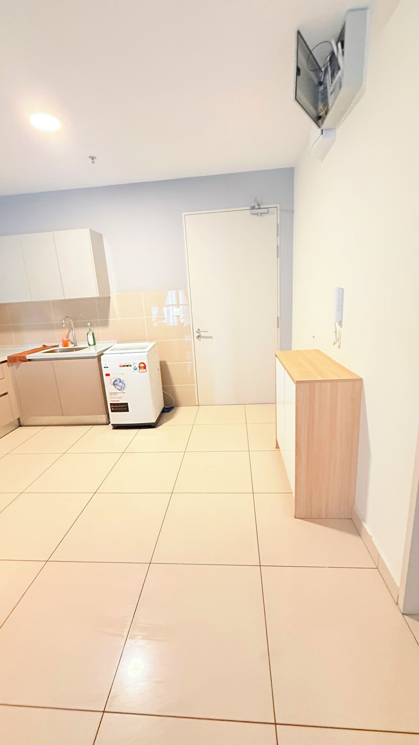 A kitchen with a washing machine, a sink, and cabinets.