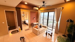 A modern hotel room with a balcony, a sofa, a dining table, and a kitchenette. - Trion KL Premier Residence (Kuala Lumpur)