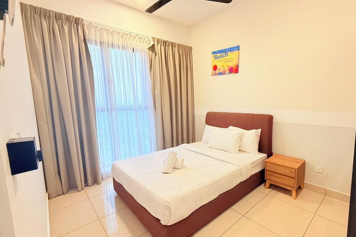 A hotel room with a bed, a nightstand, a window with curtains, and a wall poster.