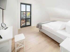 Ein modernes Schlafzimmer mit einem Bett, einem Schreibtisch und einem Stuhl.