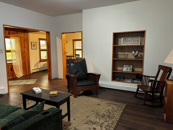 A living room with a sofa, chairs, a coffee table, a bookshelf, and a fireplace.