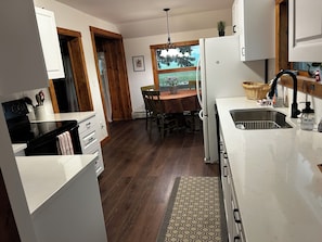 Una cocina con comedor, piso de madera y ventana con vistas.