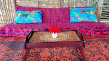 A sofa with a red and blue checkered pattern, a decorative tray with a floral centerpiece, and a patterned rug.