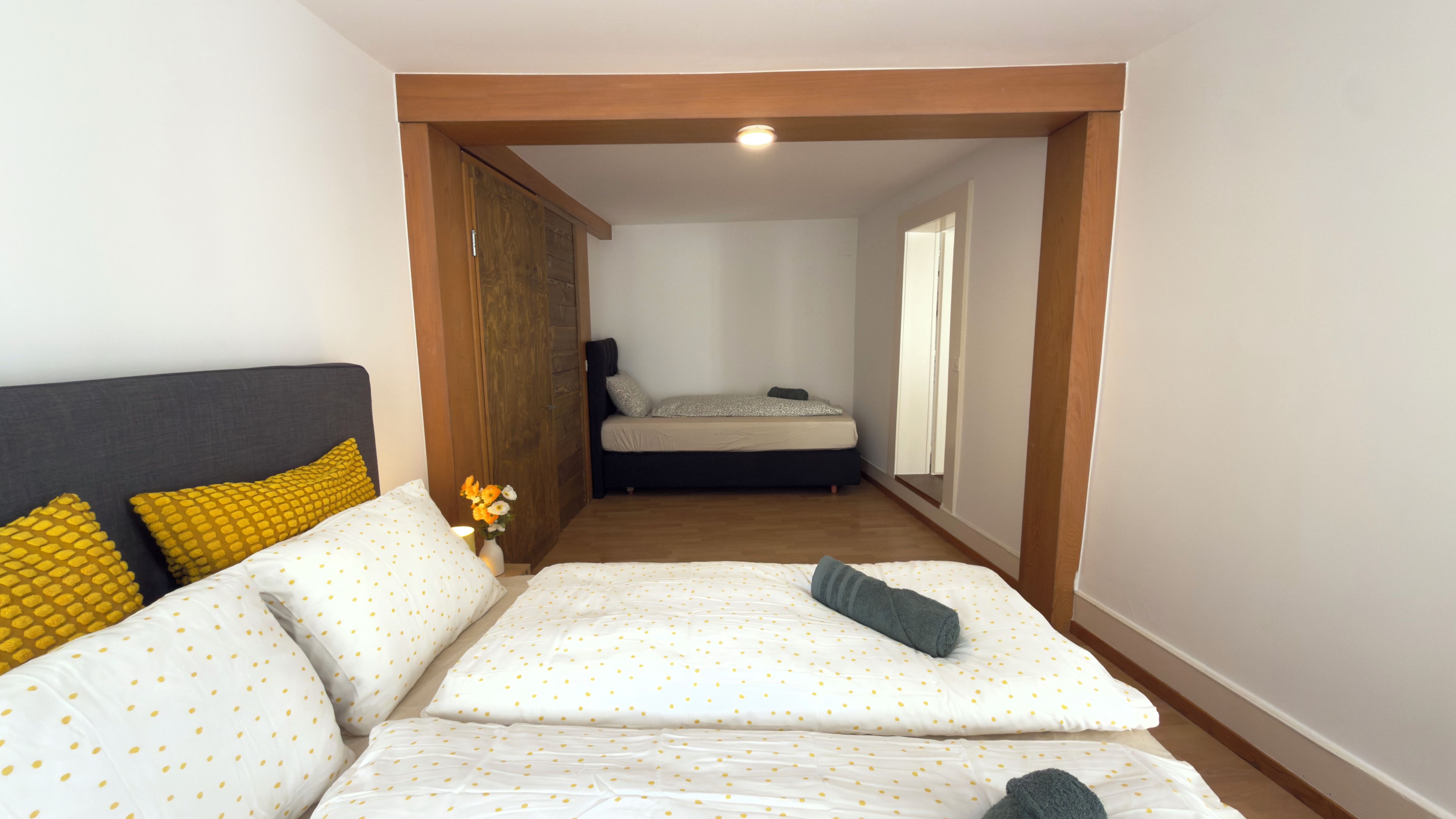 A bedroom with a bed, a nightstand, and a dresser.