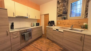 A kitchen with wooden cabinets, a built-in oven, a microwave, and a coffee maker.