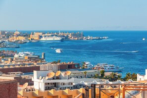 Eine Küstenstadt mit einer Marina, Gebäuden und freiem Blick auf das Meer.