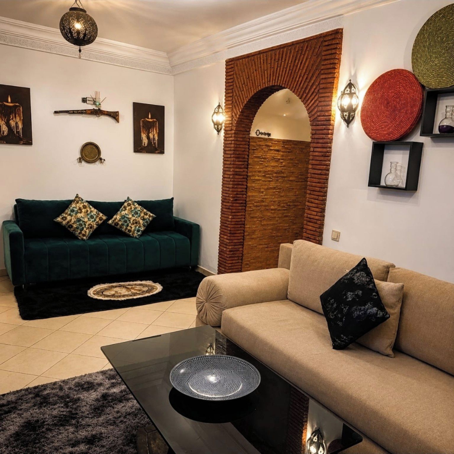 Ein Wohnzimmer mit einem grünen Sofa, einem beigen Sofa und einem Couchtisch mit einer dekorativen Schale.