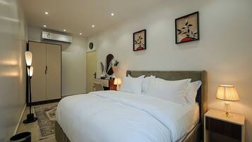 Una habitación de hotel con cama, lámpara de noche, decoración en la pared y un equipo de aire acondicionado.