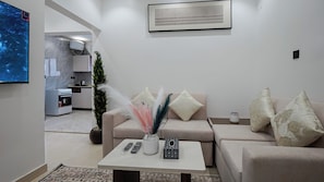 Un salon moderne avec un canapé, une table basse et un téléviseur.