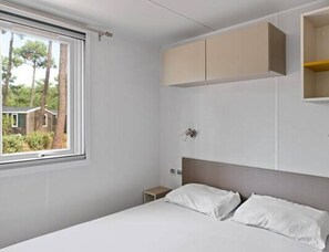 A bedroom with a bed, a window, and a wall-mounted cabinet. - Sunlit Park Umag Escape (Brtonigla)