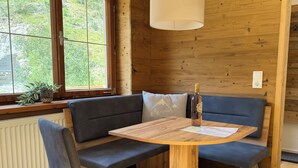 Un interior de madera con un banco, una mesa y una lámpara colgante.