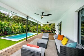 A covered outdoor area with a pool, seating, and a hammock. - Casa GaleriaDesign District Art Retreat (Miami)