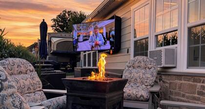 Charming recreational vehicle with a cozy sitting area, fire pit and a 65” tv.