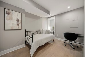Ein Schlafzimmer mit einem Bett, einem Schreibtisch und einem Stuhl.