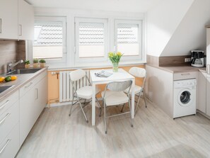 Una cocina moderna con comedor, lavadora y cafetera.