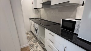 Ett modernt kök med mikrovågsugn, ugn och tvättmaskin.