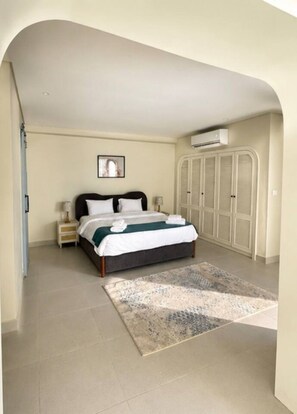 A bedroom with a bed, nightstands, a rug, and a wardrobe. - Realx at Bait Assel by Spacey #85 (cairo)