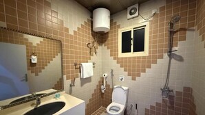 Un baño con lavamanos, inodoro y ducha.