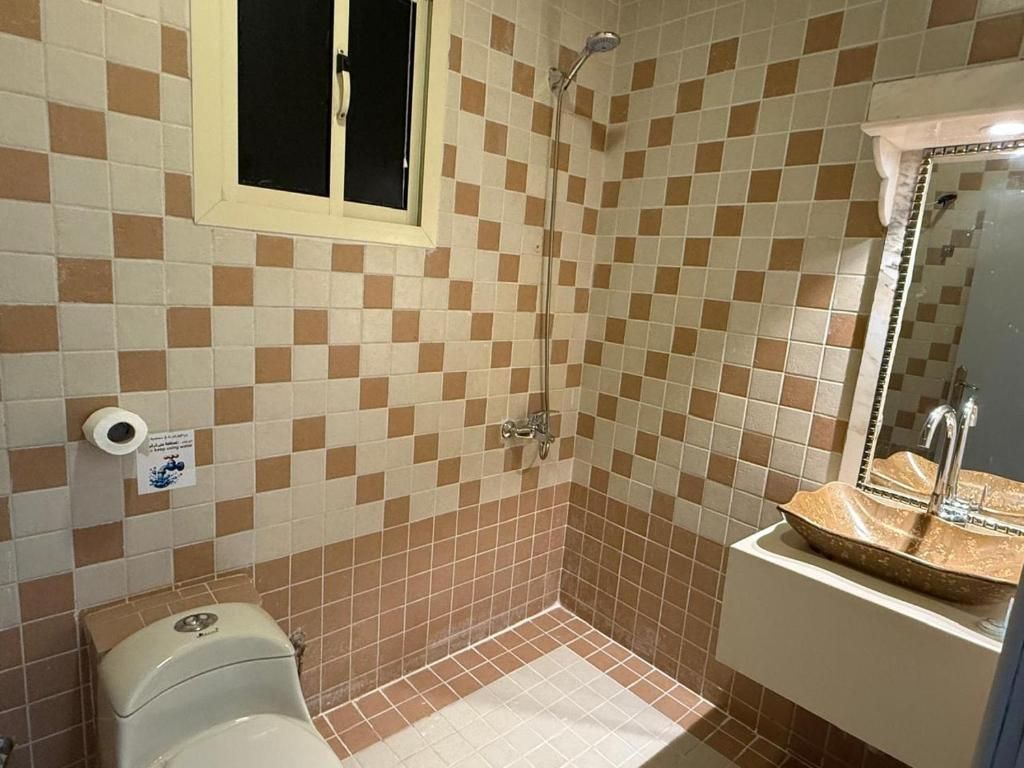 A bathroom with a toilet, shower, and sink.