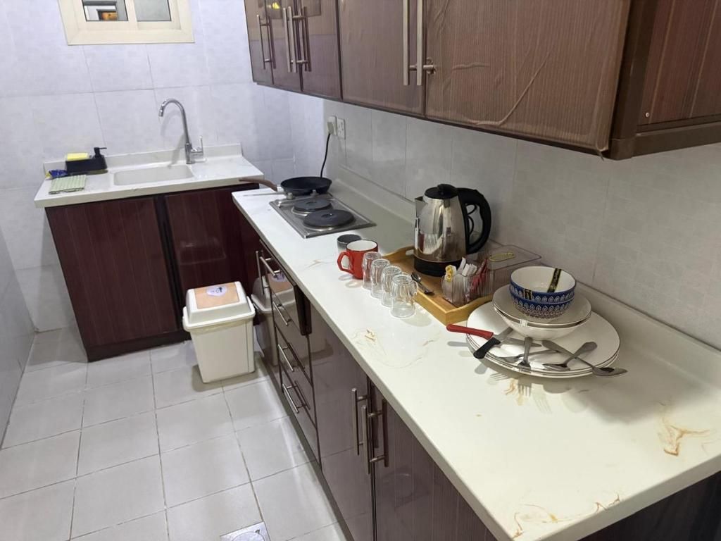 A compact kitchen with a sink, stove, and cabinets.