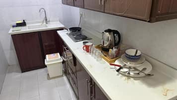 A compact kitchen with a sink, stove, and cabinets.