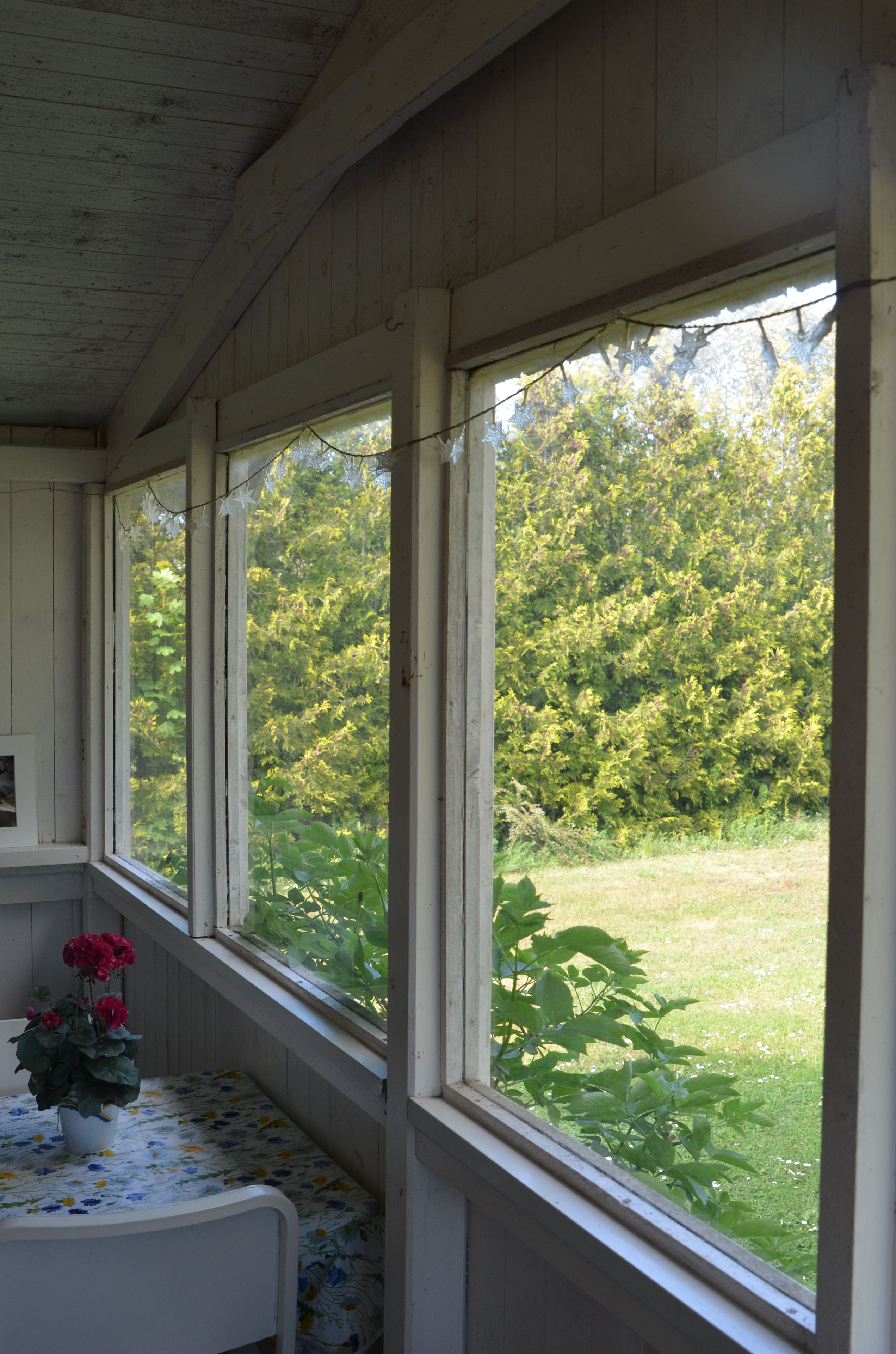 Una habitación con cama, ventana y vistas a un jardín.