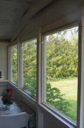 Una habitación con cama, ventana y vistas a un jardín.