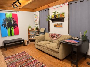 Ein gemütliches Wohnzimmer mit einer Couch, einer Bank, einem Couchtisch und einem Bücherregal.