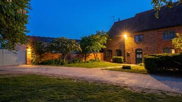 A brick house with a well-maintained lawn and a driveway leading to a garage.