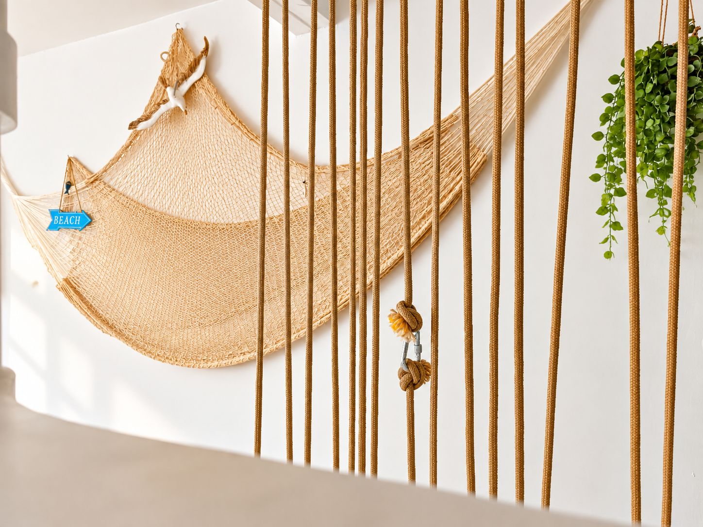 Una hamaca colgada con cuerdas, una planta pequeña y una etiqueta que dice 'BEACH'.