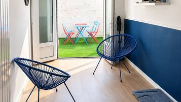 Un intérieur moderne avec un plancher en bois, une chaise bleue, une table rouge et bleue, et un luminaire suspendu.