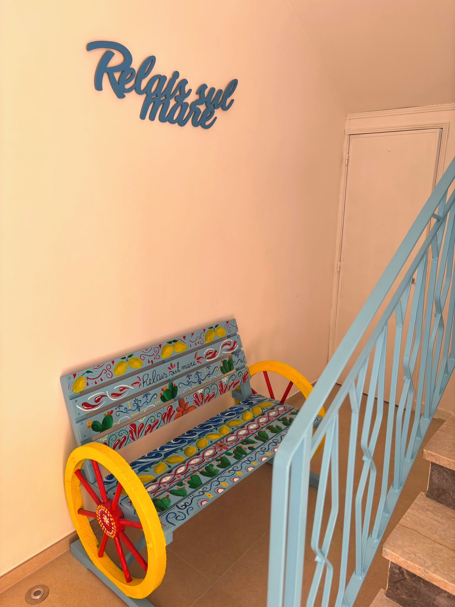 A bench with colorful patterns and a blue metal railing.