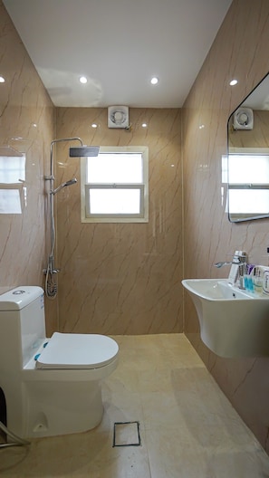Une salle de bain comprenant des toilettes, un bidet et un lavabo.