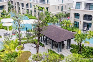 Ein Hotelinnenhof mit Pool, Sitzgelegenheiten im Freien und üppiger Bepflanzung.