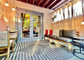 A modern living room with a sofa, a dining table, and a patterned rug. - Spacious 2BR \ 2 bath private en-suites - Both North & South Suites (Wilton Manors)