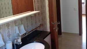 Un bagno con lavandino, specchio e porta in legno.
