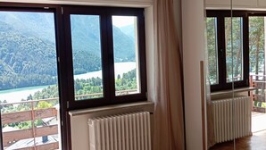 Una stanza con ampie finestre, un termosifone e vista su un paesaggio montuoso.