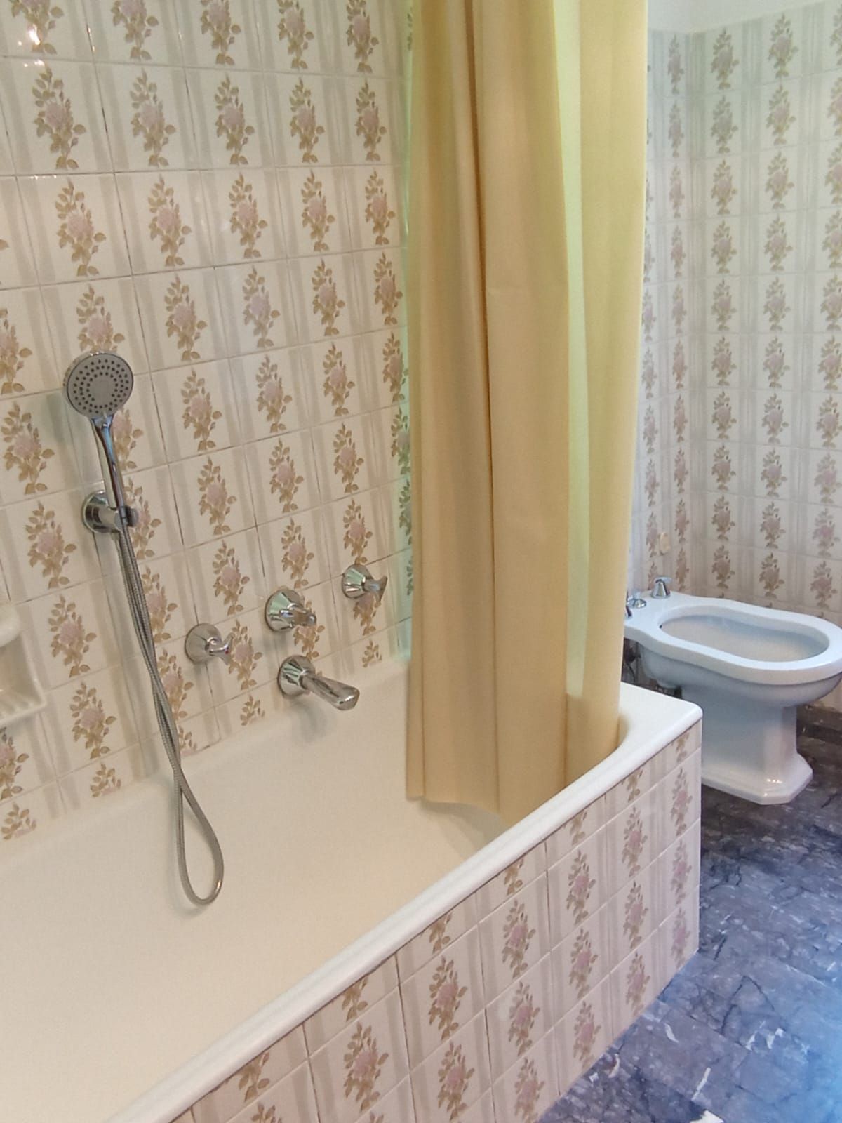Un baño con bañera, ducha e inodoro.