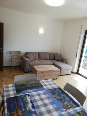 A modern living room with a sectional sofa, a wooden coffee table, and a checkered table runner.